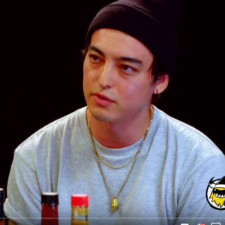 Joji wearing the Hand of God necklace